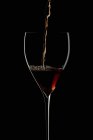 Красное вино капает в бокал — стоковое фото