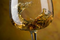 Swirling cognac in glass — Stock Photo
