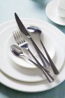 Elevated view of white plates and cutlery — Stock Photo