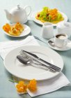 Closeup view of white place setting with orange slices and coffee — Stock Photo
