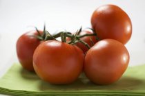 Fresh tomatoes on green cloth — Stock Photo