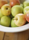 Apples in white bowl — Stock Photo