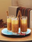 Closeup view of cocktails with cinnamon sticks in glasses — Stock Photo