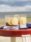 Nahaufnahme eines Afterglow-Cocktails mit Guaven-Scheiben auf dem Strandtisch — Stockfoto
