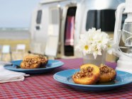 Closeup view of baked peaches with nut stuffing and camper van on background — Stock Photo