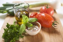 Ingredients for tomato sauce: tomatoes, herbs, olive oil, spices on wooden desk — Stock Photo
