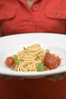 Frau hält Teller mit Spaghetti — Stockfoto