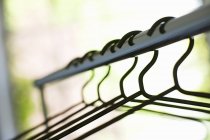 Closeup view of clothes rail with coat hangers — Stock Photo
