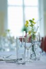 Closeup view of laid table with flowers and glassware — Stock Photo