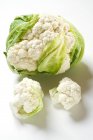 Whole cauliflower and individual florets — Stock Photo