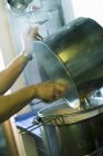 Руки спорожнюють одну сковороду в іншу на кухні ресторану — стокове фото