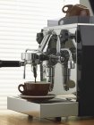Nahaufnahme von Espresso läuft aus verchromter Espressomaschine in Tasse — Stockfoto