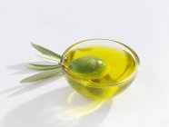 Зеленая оливка в блюде из оливкового масла — стоковое фото