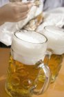 Кружки пива на столе — стоковое фото