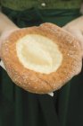 Обрезанный крупным планом вид человека, держащего на салфетке жареное баварское печенье Аусогена — стоковое фото