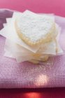 Vista close-up de corações de pastelaria empilhados com açúcar de confeiteiro — Fotografia de Stock