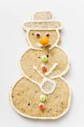 Vista close-up de um biscoito de boneco de neve temperado na superfície branca — Fotografia de Stock