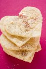 Gros plan vue du dessus des biscuits empilés en forme de coeur d'amande avec du sucre — Photo de stock