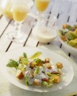 Крупним планом салат Цезар на білій тарілці з соусом та соком — стокове фото