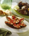 Carciofi con peperoni a dadini su piatto bianco sopra tavolo — Foto stock