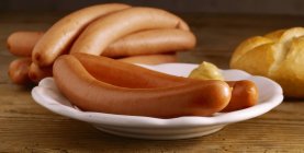 Frankfurters with mustard on white plate — Stock Photo