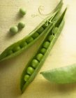 Opened pea pods with peas — Stock Photo
