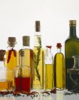Verschiedene Arten von Öl in Flaschen mit Kräutern und Gewürzen — Stockfoto