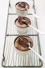 Крупним планом три шоколадні суфле в мисках, наповнені шоколадним соусом — стокове фото