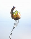 Closeup view of prawn with parsley and sliver of carrot on fork — Stock Photo