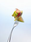 Melon with lettuce and ham on fork — Stock Photo