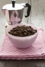 Vista elevada de la olla Espresso con un pequeño tazón de granos de café - foto de stock
