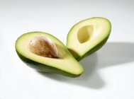 Halbierte Avocado mit Stein — Stockfoto