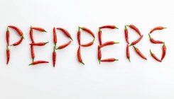 Word peppers written in red chillies — Stock Photo