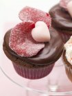 Cupcake al cioccolato con petali di rosa zuccherati — Foto stock
