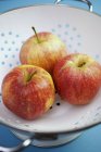 Три яблока в дуршлаге — стоковое фото