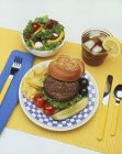 Вид крупним планом гамбургер з солінням, чіпсами, салатом та чаєм з льодом — стокове фото