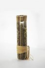Variedad de hierbas secas en tubos de vidrio atados sobre un fondo blanco - foto de stock