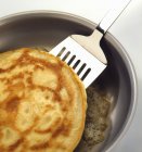 Frying a pancake on frying pan — Stock Photo