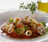 Vista close-up de frutos do mar com legumes em molho de tomate — Fotografia de Stock