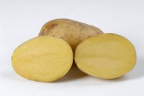 Целый картофель и две половинки картошки — стоковое фото