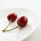 Two cherries on plate — Stock Photo
