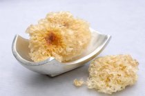 Closeup view of dried white fungus on small metal dish and beside it — Stock Photo