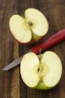 Наполовину яблуко з ножем — стокове фото