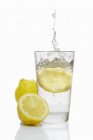 Fatia de limão caindo em vidro — Fotografia de Stock