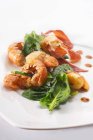 Жареные морепродукты со шпинатом и беконом на белой тарелке — стоковое фото