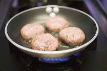 Frying burgers in pan — Stock Photo