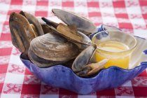 Крупный план моллюсков с маслом в голубой тарелке — стоковое фото