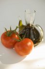 Tomates fraîches et carafe d'huile — Photo de stock