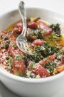 Acelga al horno y tomates en plato blanco con tenedor - foto de stock