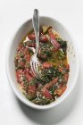 Печь и томаты на белой тарелке с вилкой на белом фоне — стоковое фото